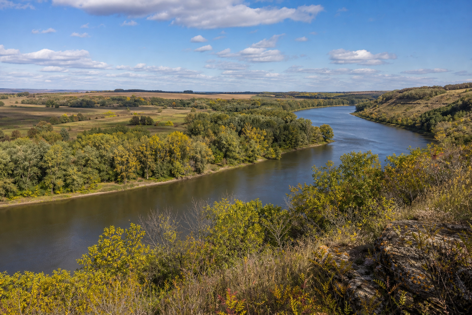 Illustrative autumn view across the Minnesota River valley bordered by prairie and wooded slopes.